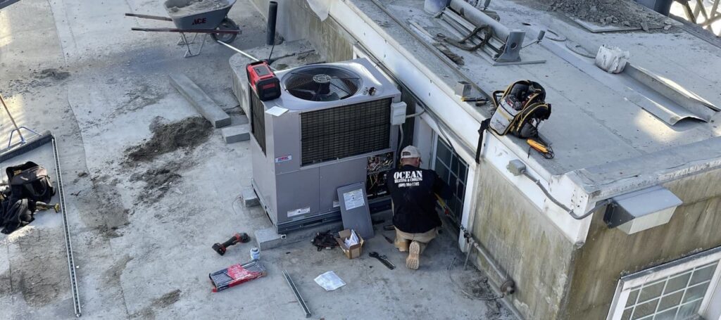 ocean heating and cooling technician performing repair services on commercial ac system