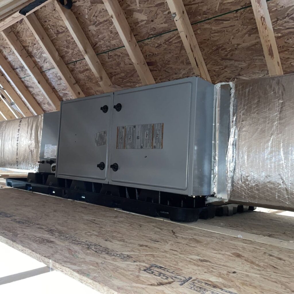large hvac unit with ducts connected to it in attic
