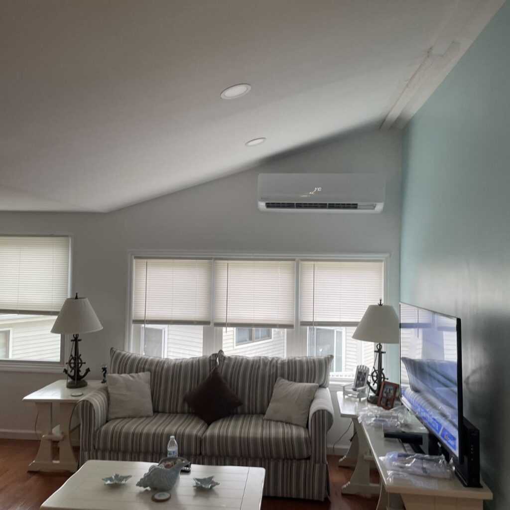 ductless ac unit positioned above windows in living room